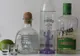 Trzy butelki tequili, dwa kieliszki i limonka na białym stole