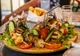 Półmisek meze w Limassol: grillowany kurczak i halloumi na szpadkach, warzywa i frytki