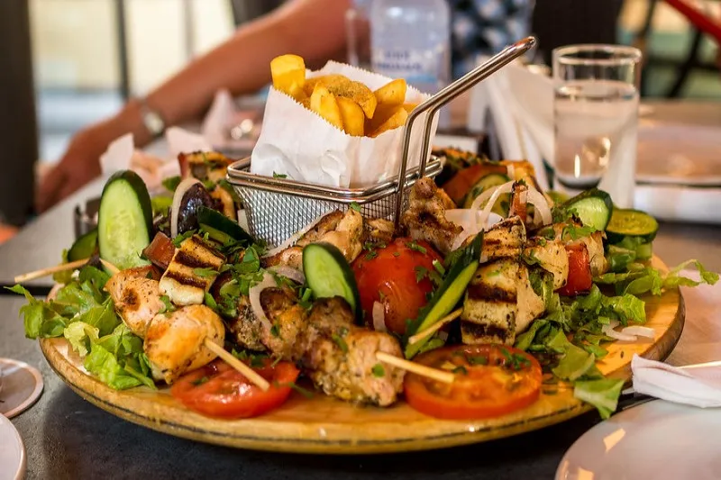 Półmisek meze w Limassol: grillowany kurczak i halloumi na szpadkach, warzywa i frytki