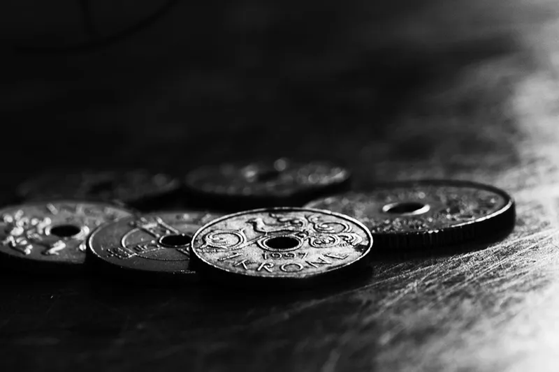 Monety jednokoronowe z otworem pośrodku, zdjęcie czarno-białe