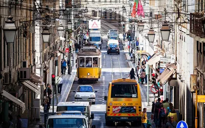 Żółte tramwaje na stromej, ruchliwej ulicy w centrum Lizbony