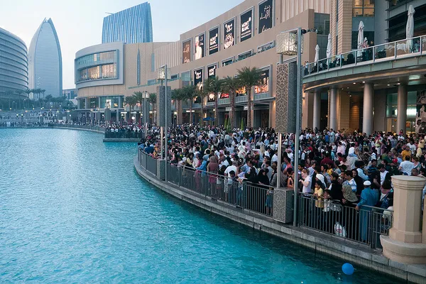 Tłum turystów przed Dubai Mall nad jeziorem, na którym odbywają się pokazy fontanny