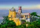 Żółte i czerwone mury Pałacu Pena z kopułą i wieżą zegarową ponad lasem Serra de Sintra