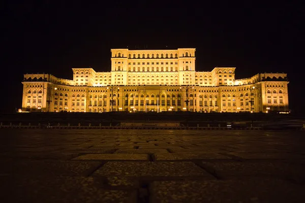 Oświetlony nocą Pałac Parlamentu w Bukareszcie – pamiątka reżimu Ceauşescu