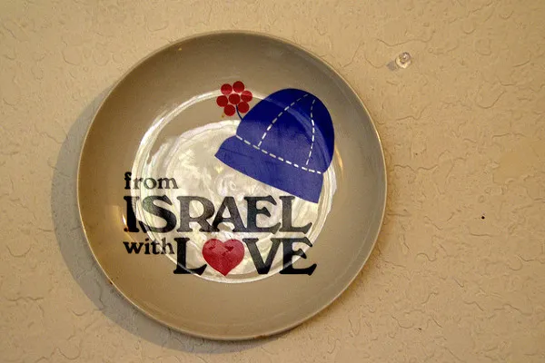 Ceramiczny talerz z jarmułką i napisem „From Israel with love” zawieszony na ścianie