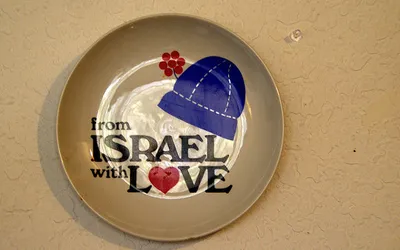 Ceramiczny talerz z jarmułką i napisem „From Israel with love” zawieszony na ścianie