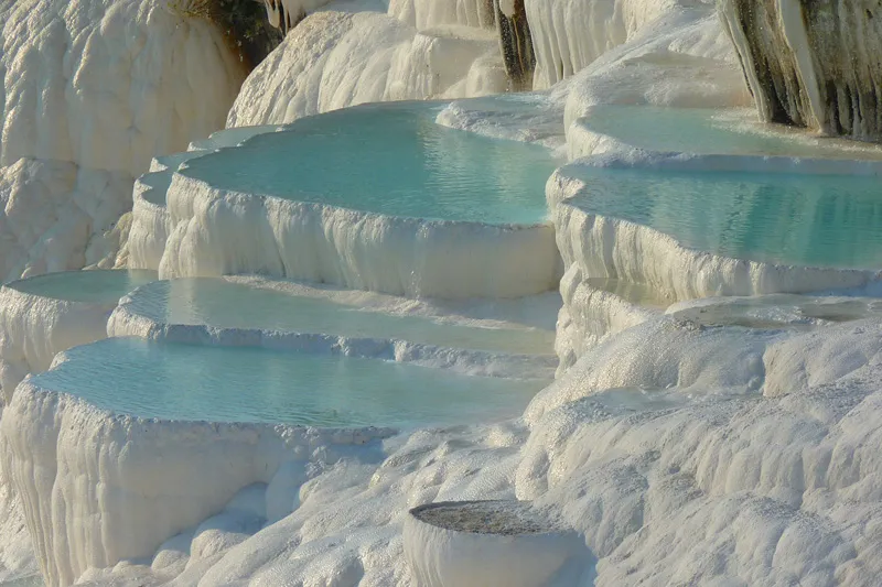 Pamukkale słynie ze swoich białych, wapiennych basenów wypełnionych błękitną wodą