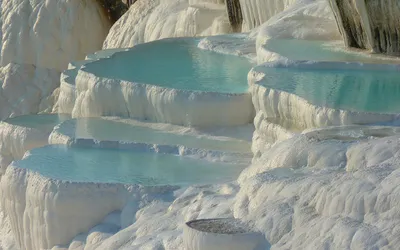 Pamukkale słynie ze swoich białych, wapiennych basenów wypełnionych błękitną wodą