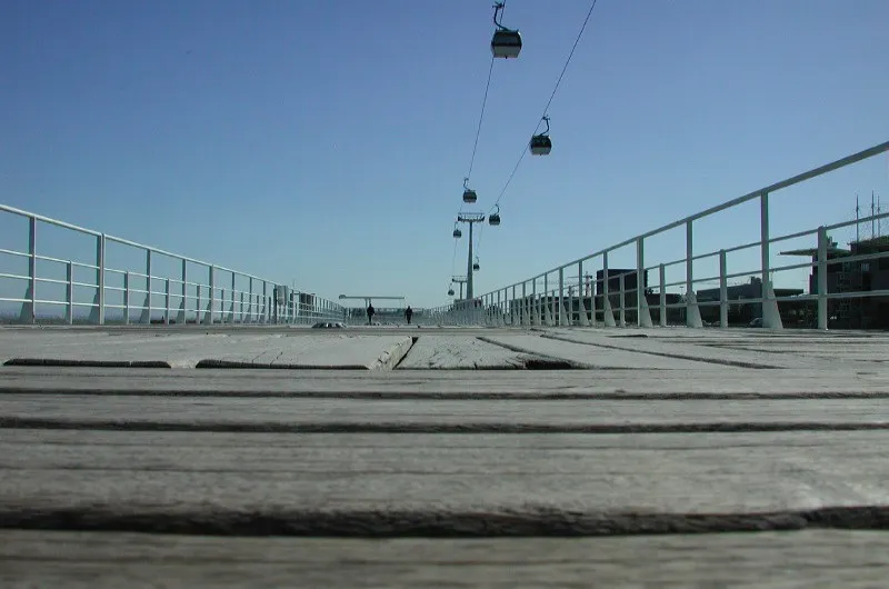 Drewniana promenada Parque das Nações w Lizbonie z gondolami kolejki linowej nad głową