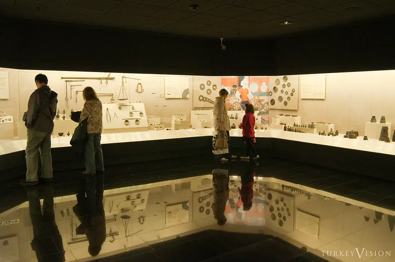Zwiedzający przy gablotach z kolekcją anatolijskich wag i miar w Muzeum Pera