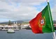 Portugalska flaga na promie wpływającym do portu w Madalenie na wyspie Pico