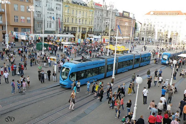 Niebieskie tramwaje i tłum przechodniów na placu bana Josipa Jelačića w Zagrzebiu