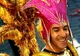 Uśmiechnięty uczestnik karnawału w Redondo w złotym stroju i różowym nakryciu głowy