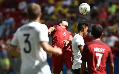 Piłkarz Portugalii w czerwonej koszulce i rywal z Niemiec walczą o piłkę głową w meczu igrzysk w Rio 2016