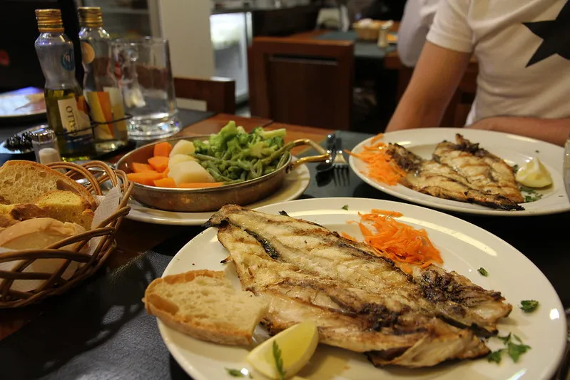 Grillowana ryba z warzywami i pieczywem w restauracji w Lizbonie