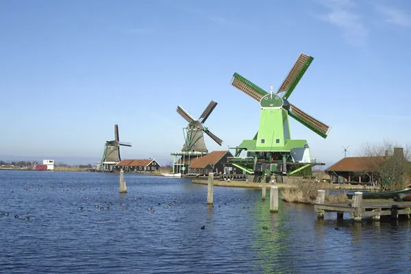 Zielone drewniane wiatraki nad rzeką Zaan w skansenie Zaanse Schans