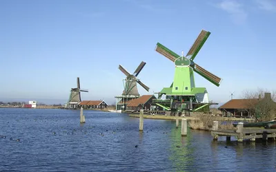 Zielone drewniane wiatraki nad rzeką Zaan w skansenie Zaanse Schans