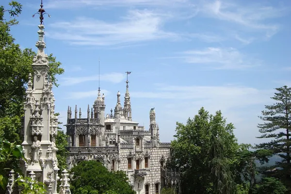 Portugalia | Widok na rezydencję Quinta da Regaleira Zdobione wieżyczki pałacu Quinta da Regaleira wśród drzew parku w Sintrze