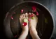 Stopy moczone w misie z wodą, płatkami róż i limonką podczas zabiegu spa