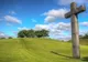 Drewniany krzyż na zielonym wzgórzu, symbol chrześcijaństwa – największej mniejszości religijnej w ZEA