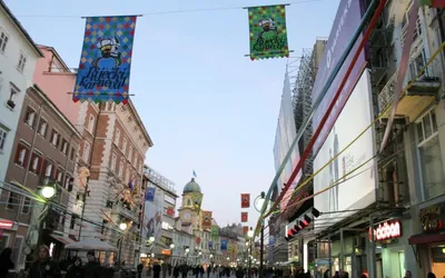 Ozdobiona karnawałowymi flagami ulica Korzo w Rijece o zmierzchu