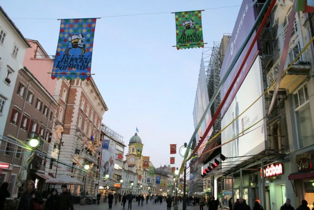 Ozdobiona karnawałowymi flagami ulica Korzo w Rijece o zmierzchu