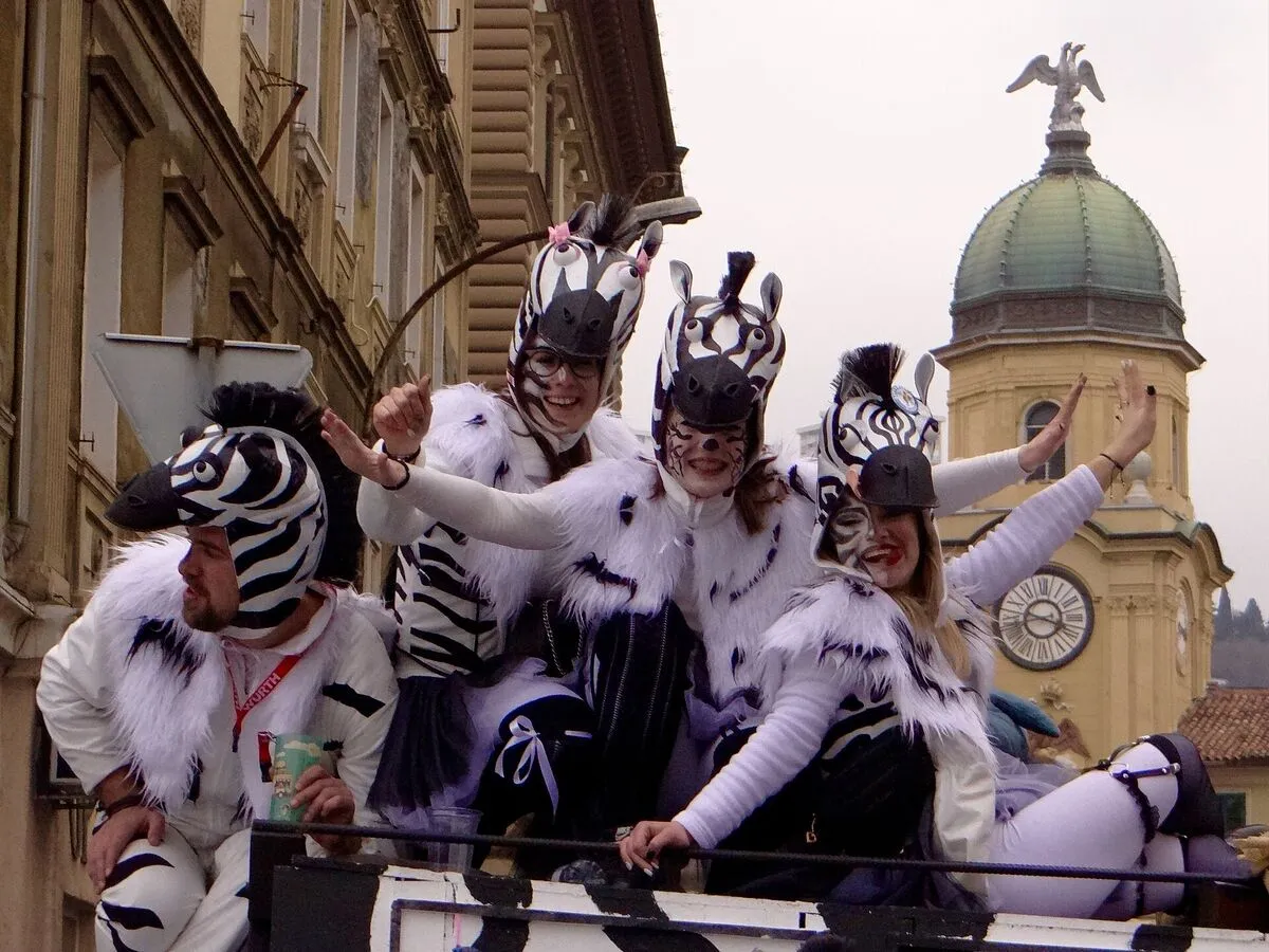 Uczestnicy karnawału w Rijece przebrani za zebry na tle wieży zegarowej