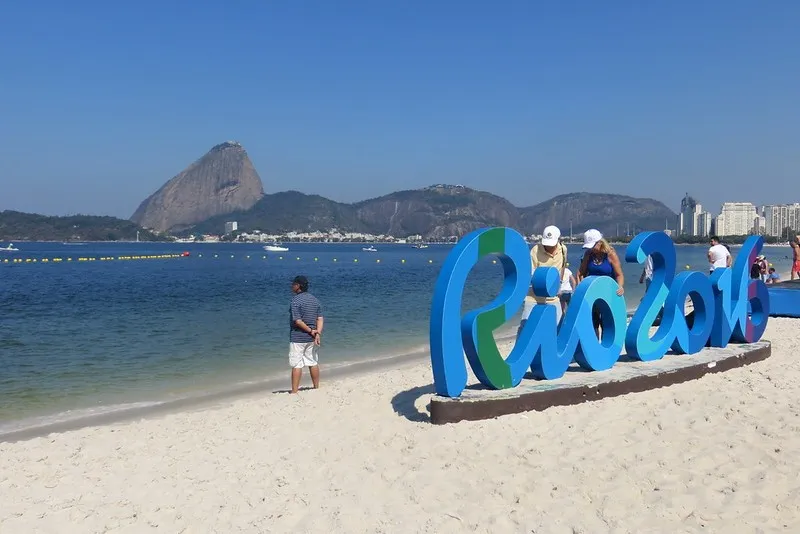 Napis Rio 2016 na plaży w Rio de Janeiro, w tle Głowa Cukru
