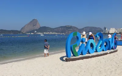 Napis Rio 2016 na plaży w Rio de Janeiro, w tle Głowa Cukru