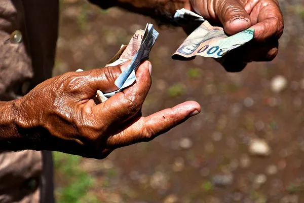 Dłonie odliczające banknoty rupii indonezyjskiej