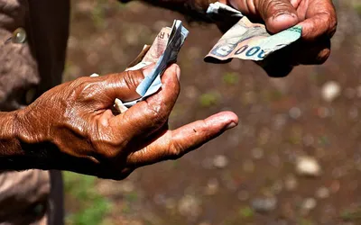 Dłonie odliczające banknoty rupii indonezyjskiej