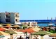 Hotel z kolorowymi parasolami nad Morzem Czerwonym w Safadży, w tle windsurferzy