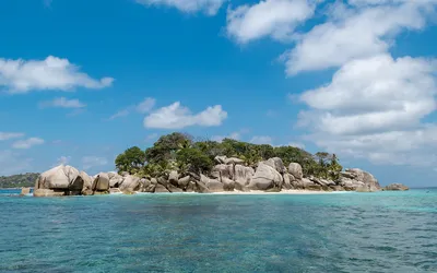 Granitowe głazy i palmy na wysepce Coco Island na Seszelach