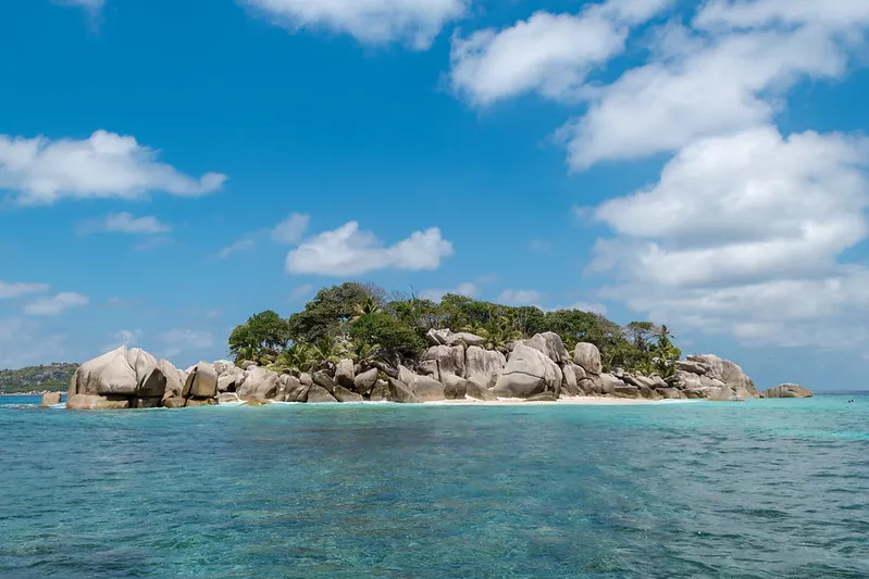 Granitowe głazy i palmy na wysepce Coco Island na Seszelach
