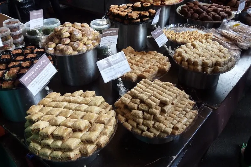 Tace z baklawą pistacjową, migdałową i innymi słodyczami na straganie