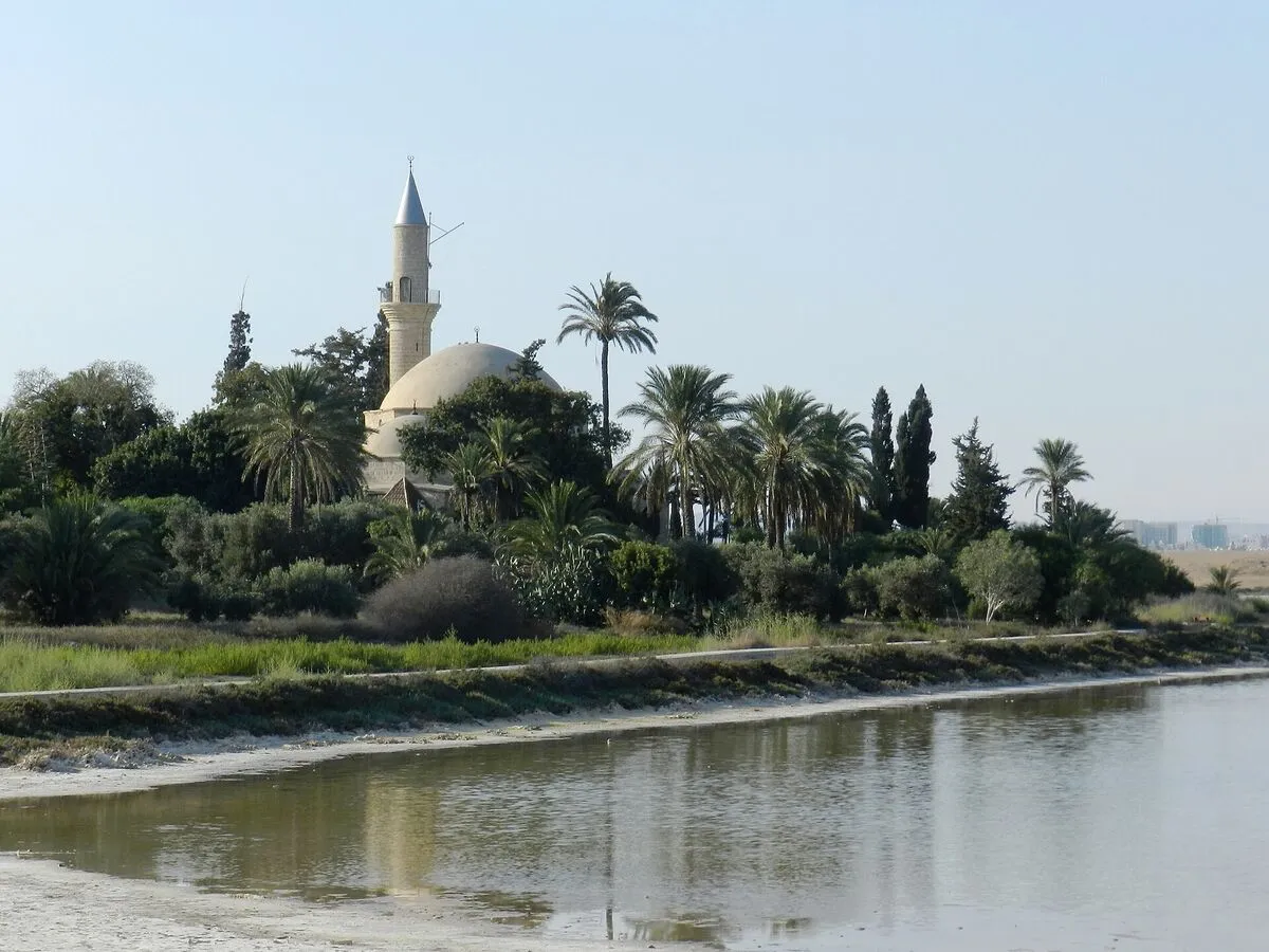 Meczet Hala Sultan Tekke z minaretem i kopułą wśród palm nad brzegiem Słonego Jeziora w Larnace