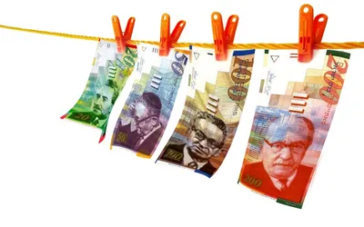 Banknoty 20, 50, 100 i 200 szekli starszej serii przypięte klamerkami do sznurka
