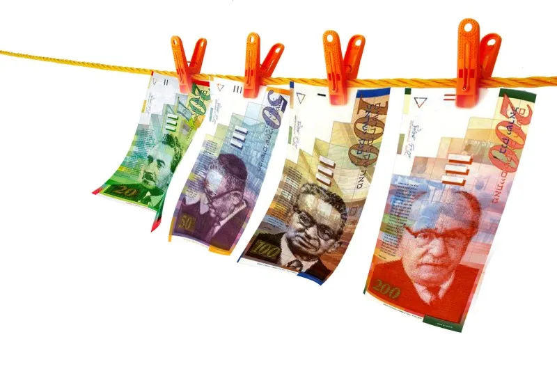 Banknoty 20, 50, 100 i 200 szekli starszej serii przypięte klamerkami do sznurka
