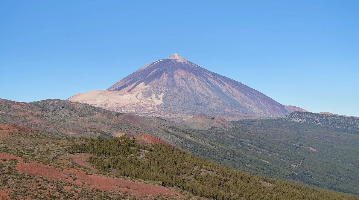 Stożek wulkanu Teide na Teneryfie wznoszący się nad sosnowymi lasami