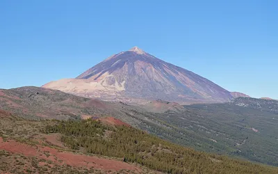 Stożek wulkanu Teide na Teneryfie wznoszący się nad sosnowymi lasami