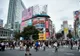 Tłum przechodniów na skrzyżowaniu Shibuya w Tokio, otoczonym wieżowcami z reklamami