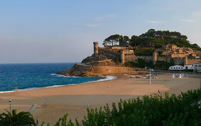 Plaża w Tossa de Mar i średniowieczne mury z basztami Vila Vella na wzgórzu