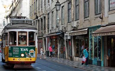 Żółty zabytkowy tramwaj linii 28 na ulicy Lizbony