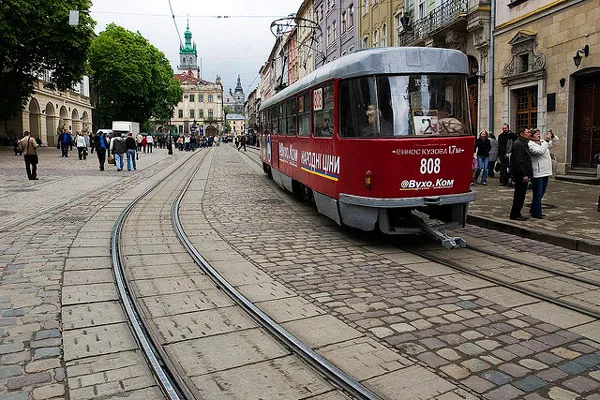 Czerwony tramwaj na brukowanej ulicy lwowskiego Starego Miasta