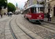 Czerwony tramwaj Tatra na brukowanej ulicy lwowskiego Starego Miasta