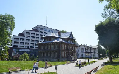 Deptak w Truskawcu z budynkiem sanatorium wśród zieleni