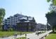 Deptak w Truskawcu z budynkiem sanatorium wśród zieleni