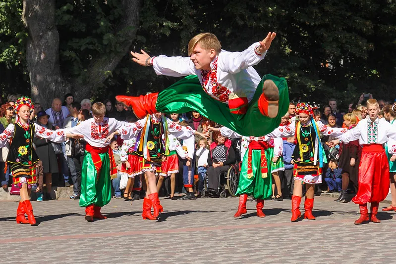 Tancerz w ukraińskim stroju ludowym w wyskoku podczas występu zespołu folklorystycznego