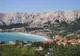 Zatoka w Bašce z długą żwirową plażą Vela, czerwonymi dachami miasteczka i skalistymi górami w tle