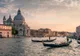 Gondole na Canal Grande i bazylika Santa Maria della Salute w Wenecji o zachodzie słońca